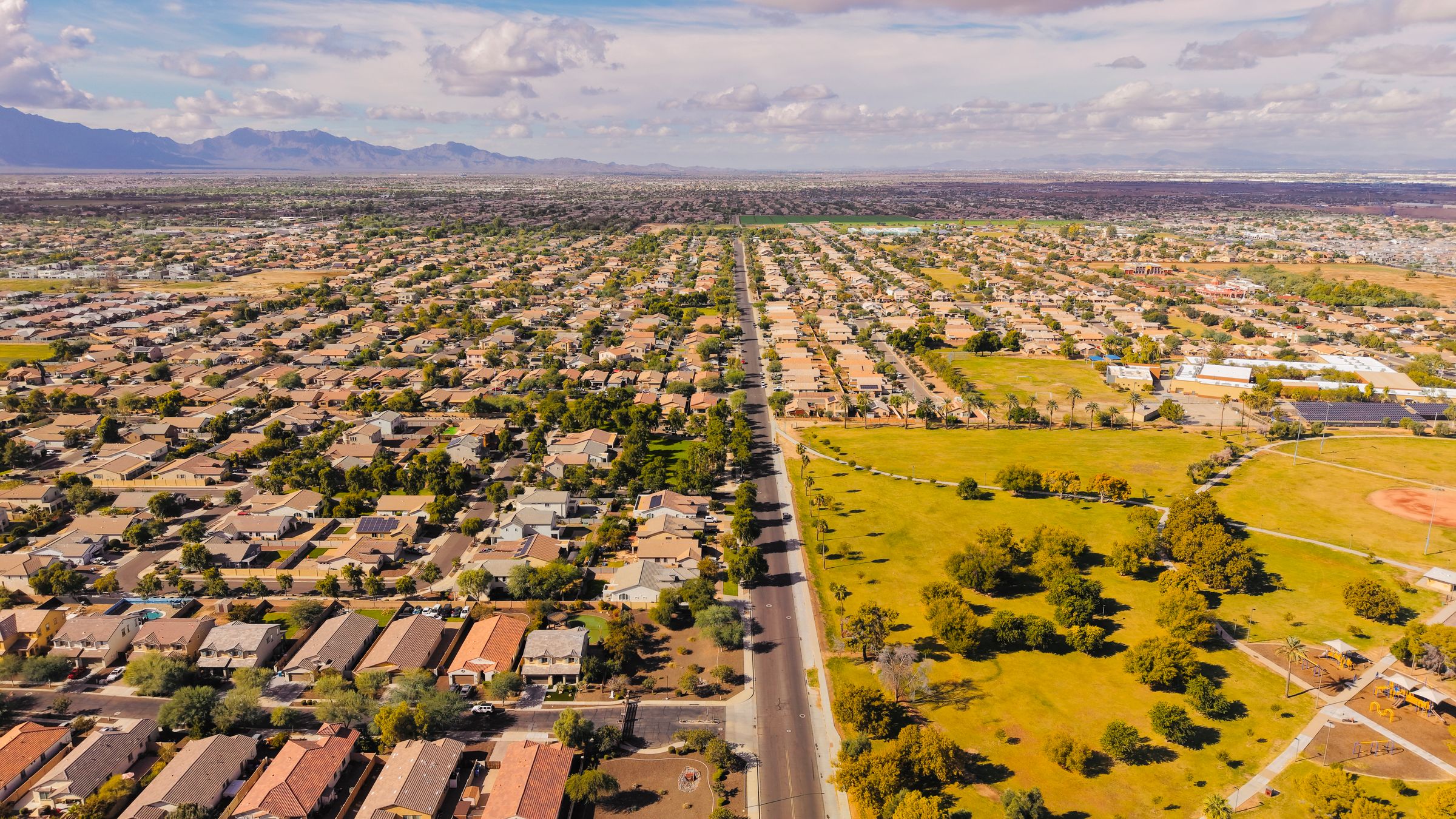 Aerial view of a Phoenix-metro suburban corridor and valley floor. Generic market context, not an Emberford project.
